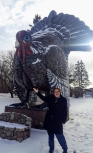 Violet standing next to a 15 foot tall turkey statue