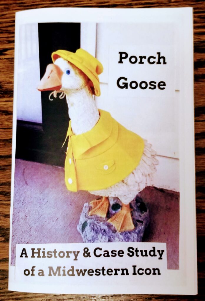 cover of the Porch Goose zine, featuring a concrete goose sculpture with a bright yellow raincoat and matching hat